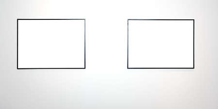 Two empty frames on white wall in museumの写真素材
