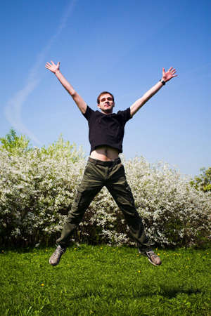 Active jumping man on green grassの写真素材