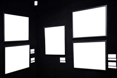 black wall in museum with empty framesの写真素材