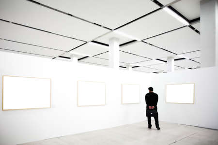 walls in museum with empty frames and person lookingの写真素材