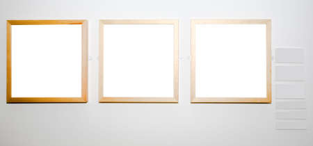 Three empty frames on white wall in museum