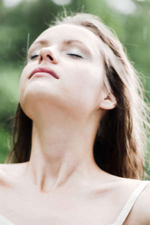 Girl stay under rain drops, head upの写真素材