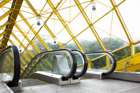 Mooving escalators and stairs, bridge with spheresの写真素材