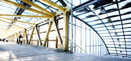 Yellow metal corridor with windows, crowd moovingの写真素材