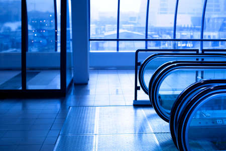 Escalator enter in blue corridor in office centreの写真素材