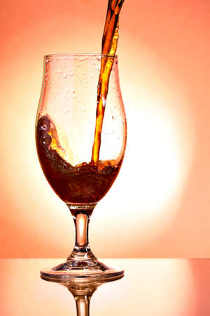 Beer glass with dark beer streamの写真素材
