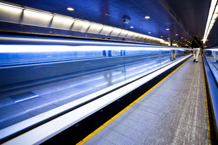 Blue moving escalator with people in Barcelona's subwayの写真素材
