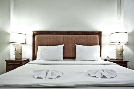 Hotel bedroom interior with pillows and lamps in eveningのeditorial素材