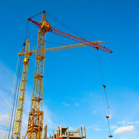 Two cranes and unfinished house