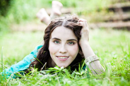 Lying pretty smiling girl with long brown hairsの写真素材