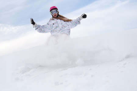 Snow splashes from girl rider snowboard の写真素材