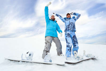 Two snowboard rider girls stay on hill の写真素材