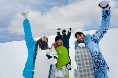 Four fun snowborders stay in mouintainsの写真素材