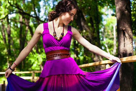 Girl in violet dress in sunny parkの写真素材
