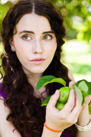 Girl in garden with green applesの写真素材