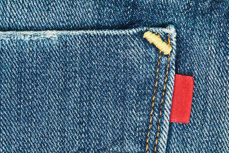 Blue old jeans pocket with empty red label close-upの写真素材