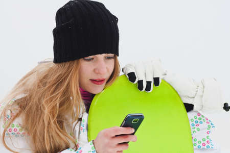 Dreaming snowboard rider girl with phoneの写真素材