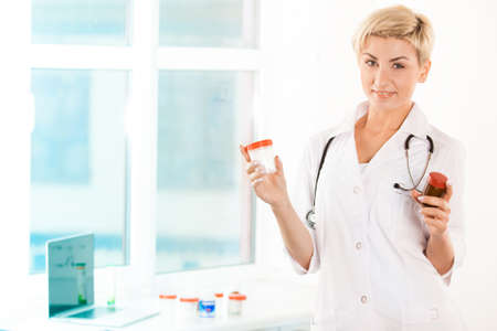 Smiling doctor with drugs in her armsの写真素材