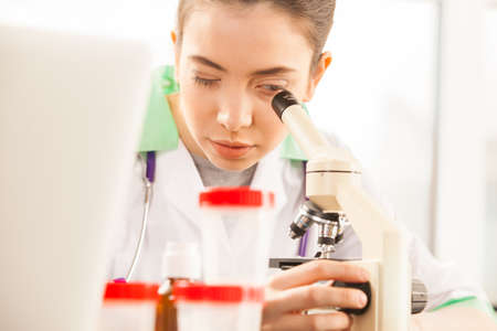 Young scientist looking into a microscope in a laboratoryの写真素材