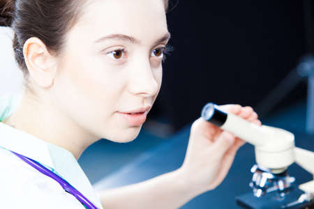 Young doctor working with microscope in lab