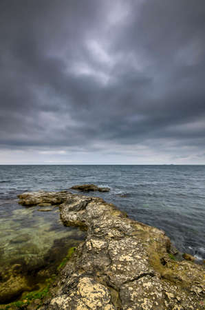 Incredibly contrast dramatic sky and rocky shore of the oceanの写真素材