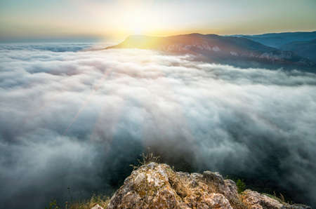 sunset from the top of the mountain above the cloudsの写真素材