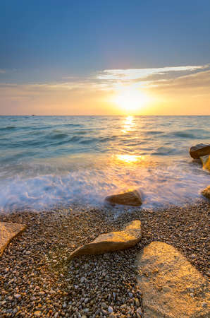 shrouded water stone on the pebble beach at sunsetの写真素材