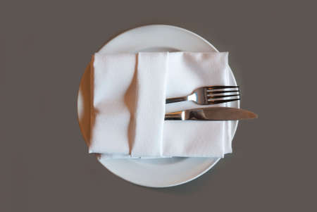 A soft toned image of a table setting with plate, napkin and utensilsの写真素材