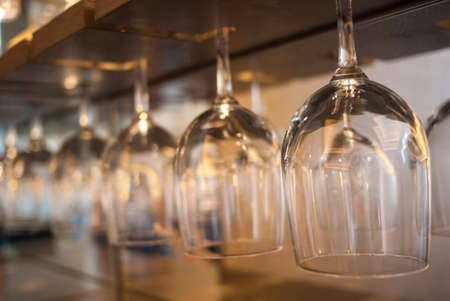 a row of wine glass hanging upside downの写真素材