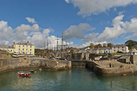 The Historic Harbour of Charlestown in Cornwall under a blue sky with tall shipsの写真素材