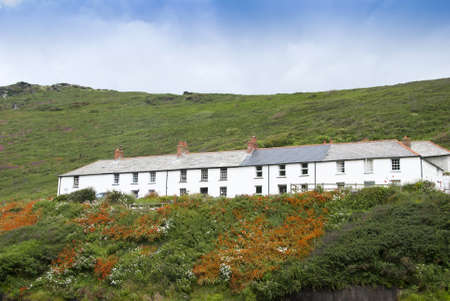 Seaside Cottages in Cornwall England on a hillside with orange crocosmia flowersの写真素材