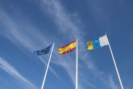 The Flags of the European Union,Spain and the Canary Islands under a blue skyの写真素材