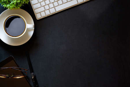 Modern dark surface office desk table with computer and cup of coffee. Hero Header Concept with Copy space.の写真素材