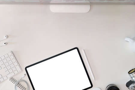 White office desk workspace table with tablet, vintage camera, lens, computer and copy spaceの写真素材