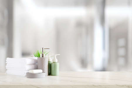 Ceramic shampoo, soap bottle and towels on counter over bathroom background. table top and copy spaceの写真素材