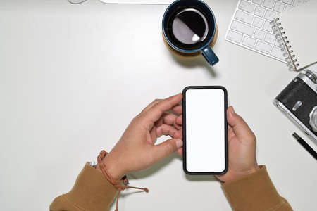 Top view man using a mobile smartphone over a workspace desk, Mockup blank screen mobile phoneの写真素材