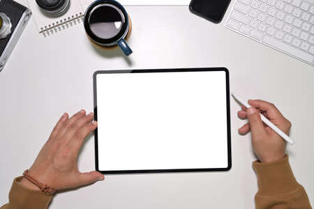 Top view of young man worker using on modern touchscreen tabletの写真素材