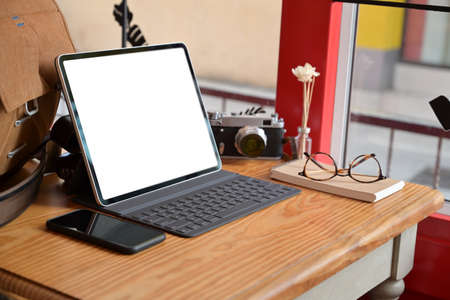 Creative photographer with mockup blank screen tablet and vintage camera gadgetの写真素材