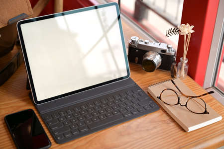 Creative photographer with mockup blank screen tablet and vintage camera gadgetの写真素材