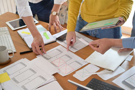 UI creative designer team designing wireframe layout for responsive mobile smartphone application in...