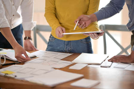 UI creative designer team designing wireframe layout for responsive mobile smartphone application in...