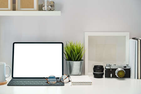 Mockup Blank screen tablet, poster, books and vintage camera on workspaceの写真素材