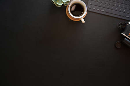 Dark leather office photography desk table with keyboard tablet and vintage camera