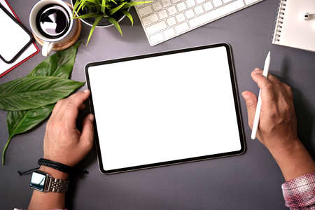 Top view man holding blank screen tablet on  home workspace deskの写真素材