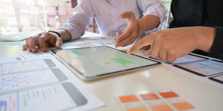 UX Designer team sketch mobile app developer outlines an app on tablet for web mobile smart phone
