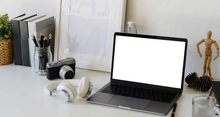 Workspace with isolate white screen mock up laptop on desk