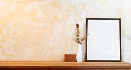 Mock up poster frame on wood table workspace and copy space
