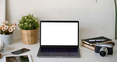 Workspace with isolate white screen mock up laptop on deskの写真素材