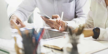 Business team uses a digital tablet and mobile phone for financial dataの写真素材