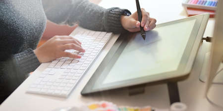 Graphic designer using digital drawing tablet and computer in studioの写真素材